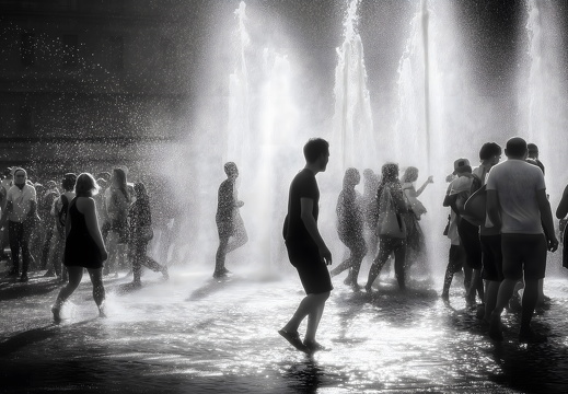 Menschen kühlen sich an Brunnen während Hitzewelle ab