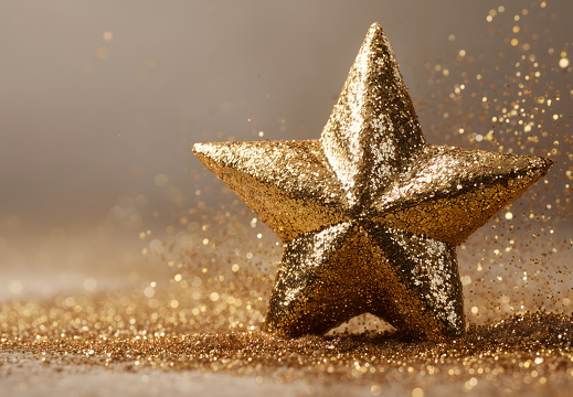 Goldener Stern mit Glitzereffekt auf weißem Hintergrund