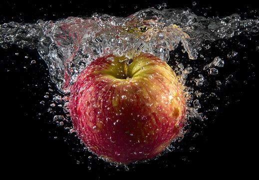 Apfel im Wasser mit Splash auf schwarzem Hintergrund