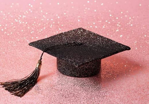 Glitzernde Abschlusskappe auf rosa Hintergrund mit Quaste