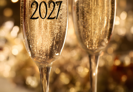 Zwei Sektgläser mit Schriftzug 2027 auf goldenem Bokeh-Hintergrund